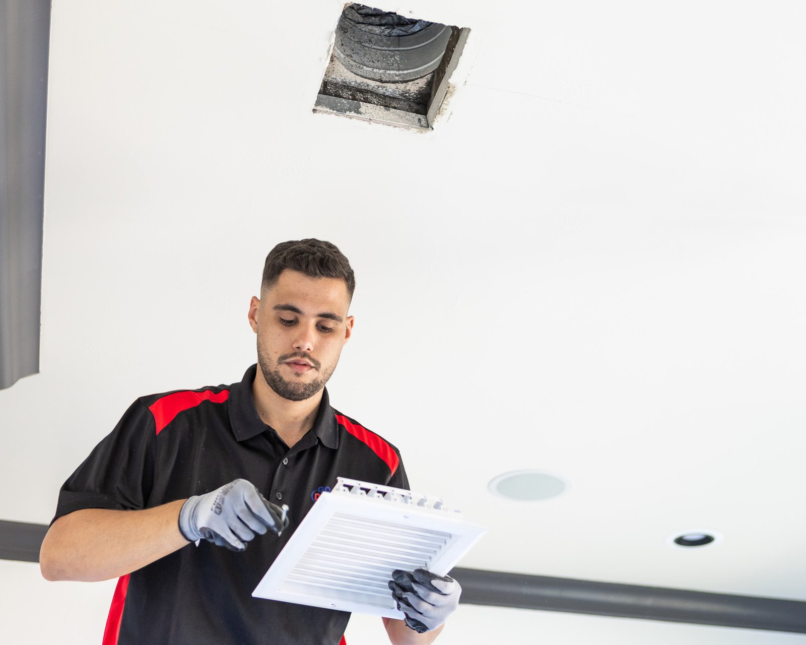 Technician installing a vent cover on a cleaned air duct system.