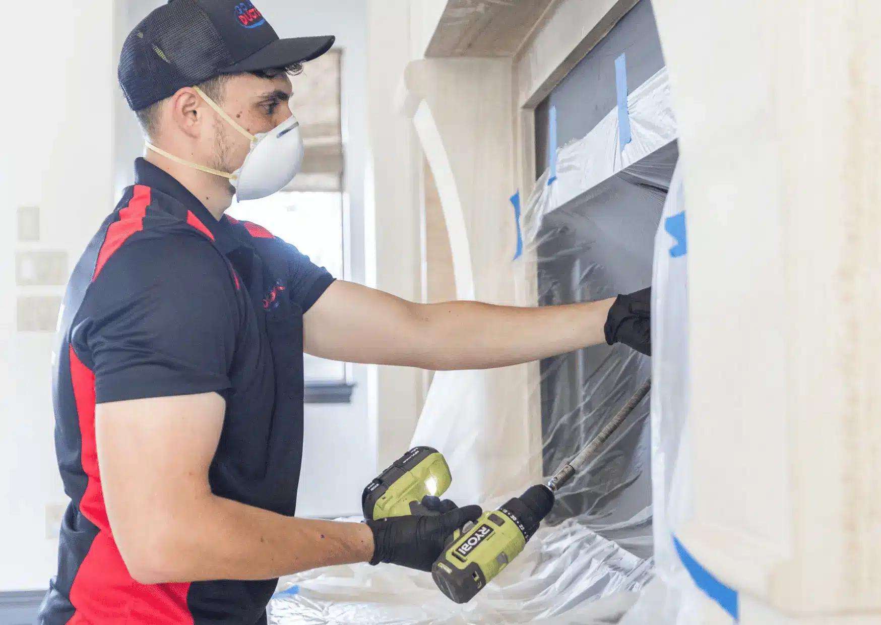 Technician cleaning ceiling air duct vent