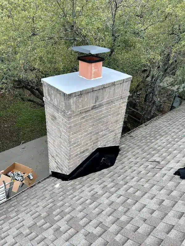 Chimney leak repair with new flashing and chimney cap installed on a brick chimney