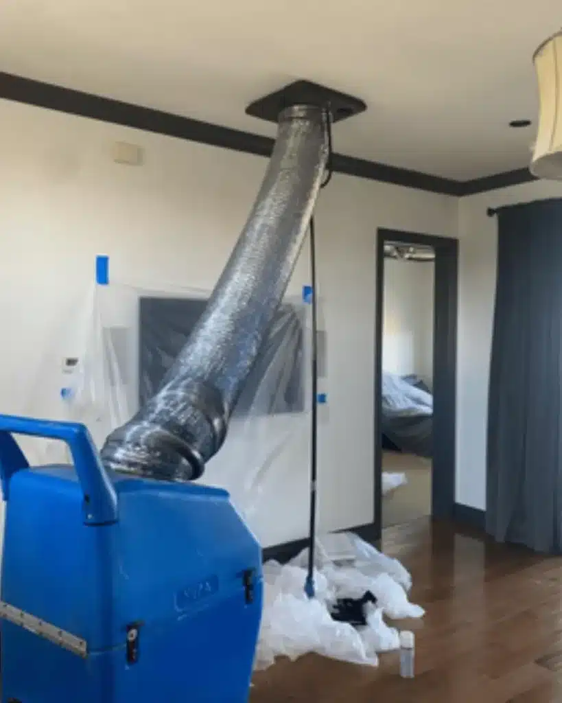 Go Air Ducts HVAC cleaning equipment in a home with duct hose attached to the ceiling vent, showing professional air duct cleaning in progress