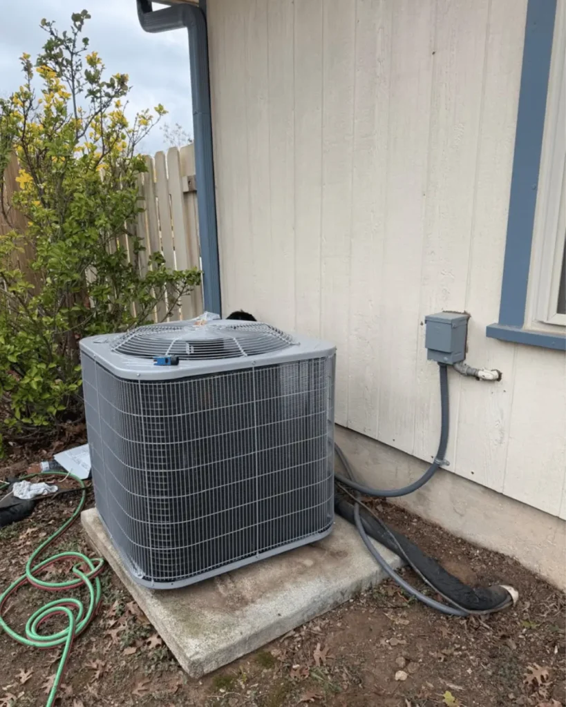 Outdoor HVAC condenser unit installed next to a residential home