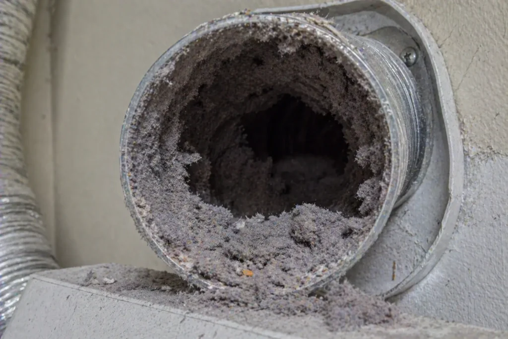 Clogged dryer vent filled with lint buildup restricting airflow